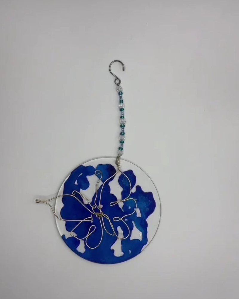 Round blue sun catcher with a wire butterfly on a beaded strand.