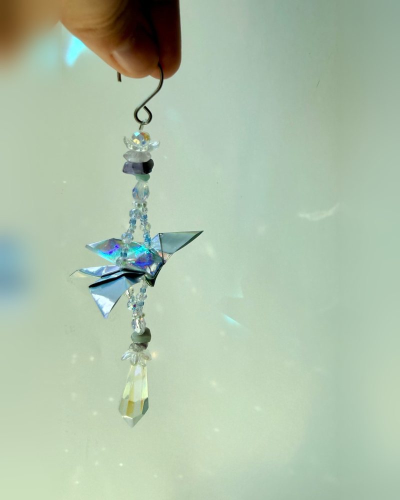 One holographic origami butterfly with crystals and a quartz point.